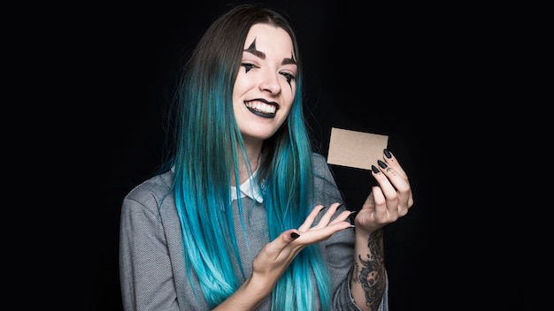 Joven mujer de pelo azul mostrando pequeña tarjeta