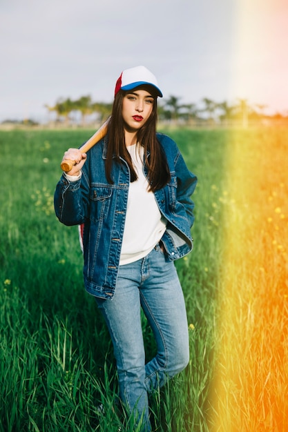 Joven mujer permaneciendo en la luz del sol