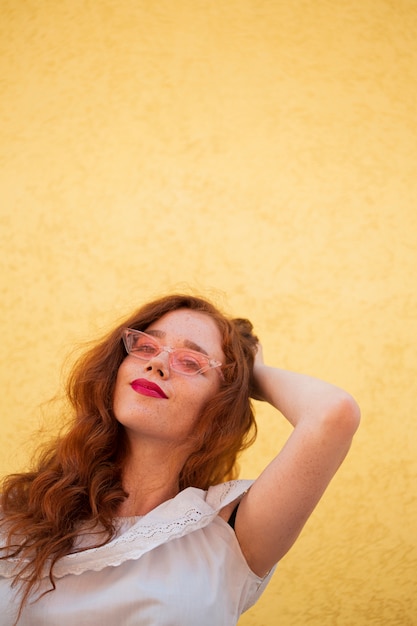 Foto gratuita joven mujer posando sobre fondo amarillo