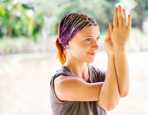 Joven mujer practicando garudasana