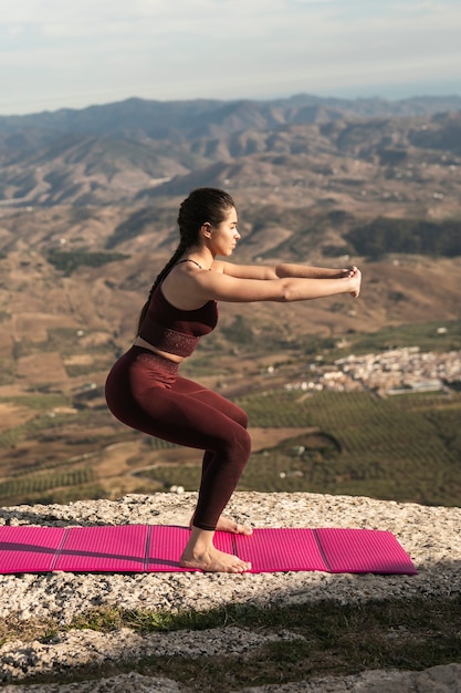 Foto gratuita joven mujer practicando yoga al aire libre