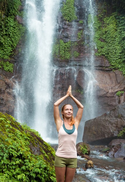 Joven, mujer, practicar, yoga, cascada