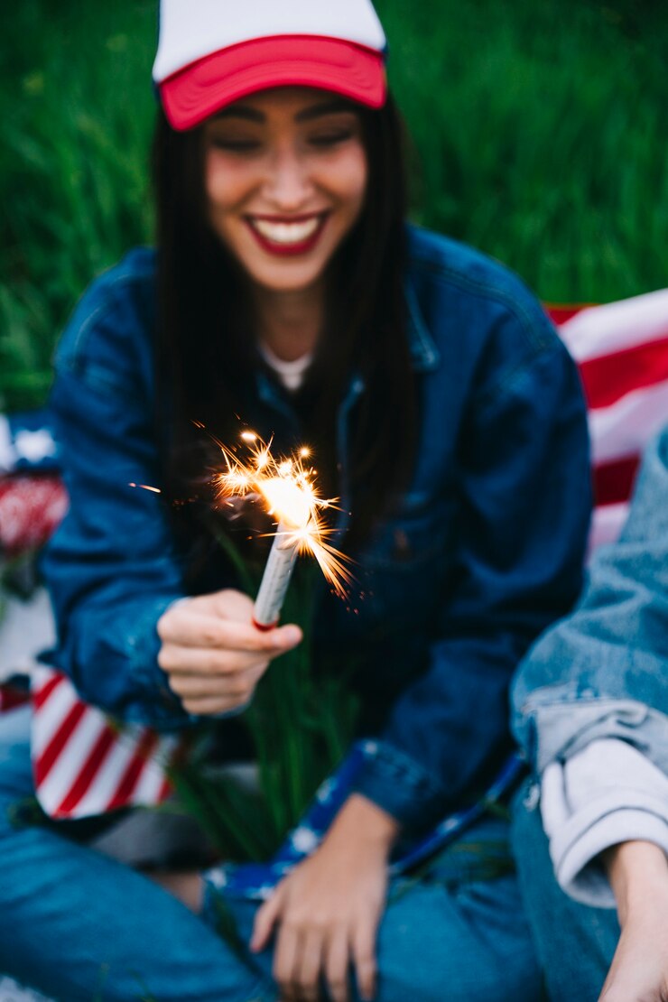 Foto gratuito joven mujer riendo con fuegos artificiales en la mano