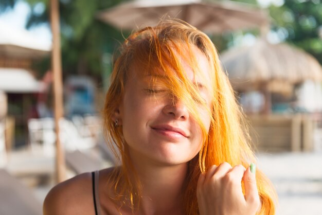 Joven mujer roja en la playa