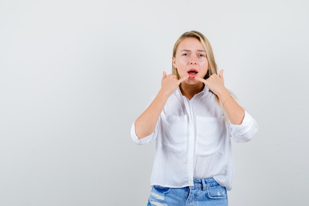 Joven mujer rubia con una camisa blanca