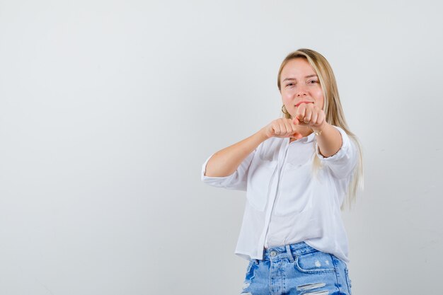 Joven mujer rubia con una camisa blanca