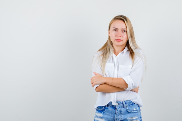 Joven mujer rubia con una camisa blanca