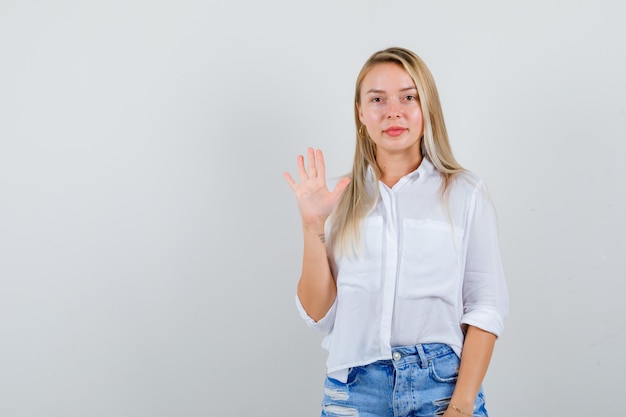 Joven mujer rubia con una camisa blanca