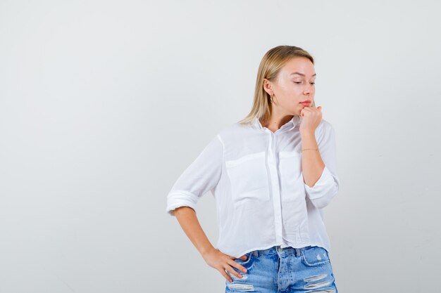 Joven mujer rubia con una camisa blanca