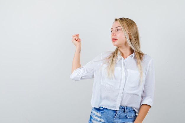 Joven mujer rubia con una camisa blanca