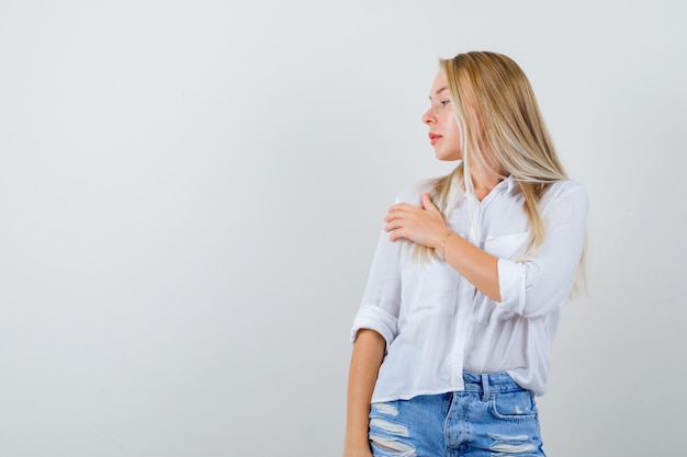 Joven mujer rubia con una camisa blanca