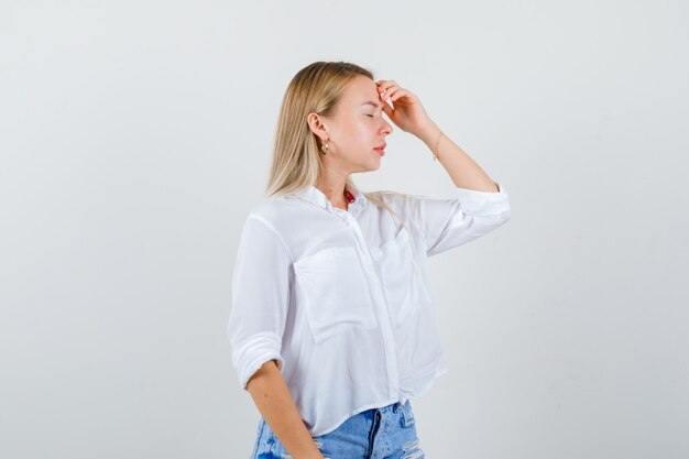 Joven mujer rubia con una camisa blanca