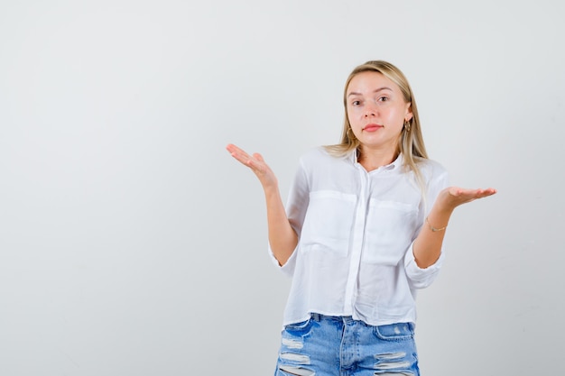 Joven mujer rubia con una camisa blanca