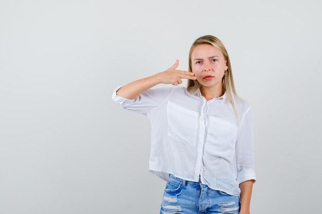 Joven mujer rubia con una camisa blanca