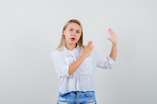 Joven mujer rubia con una camisa blanca