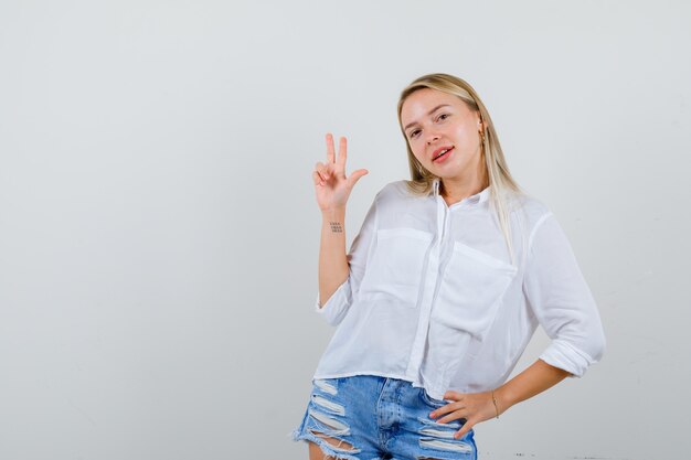 Joven mujer rubia con una camisa blanca