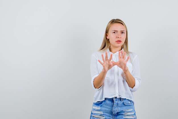 Joven mujer rubia con una camisa blanca