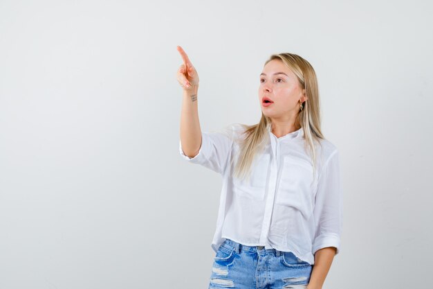 Joven mujer rubia con una camisa blanca