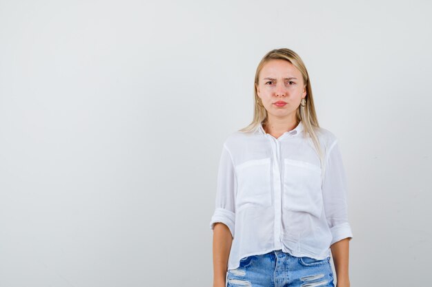 Joven mujer rubia con una camisa blanca