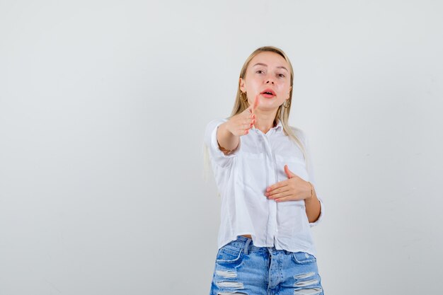 Joven mujer rubia con una camisa blanca