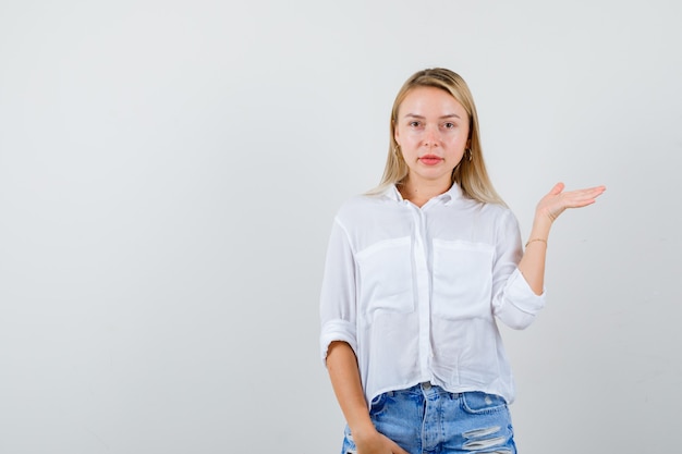 Joven mujer rubia con una camisa blanca