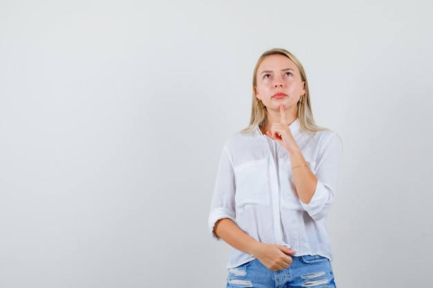 Joven mujer rubia con una camisa blanca