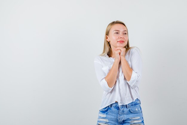 Joven mujer rubia con una camisa blanca