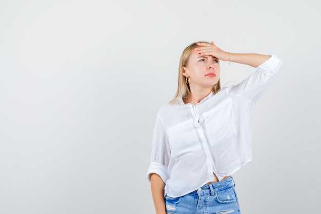 Joven mujer rubia con una camisa blanca