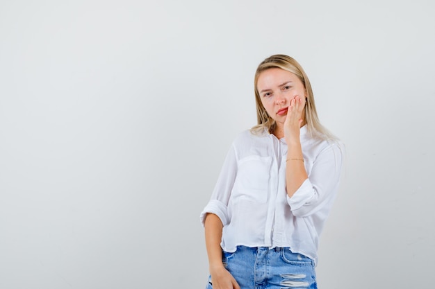 Joven mujer rubia con una camisa blanca