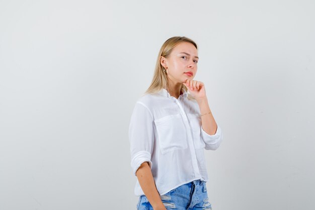 Joven mujer rubia con una camisa blanca