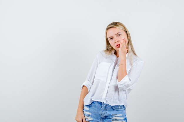 Joven mujer rubia con una camisa blanca