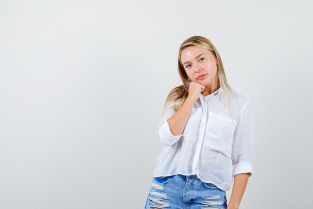 Joven mujer rubia con una camisa blanca