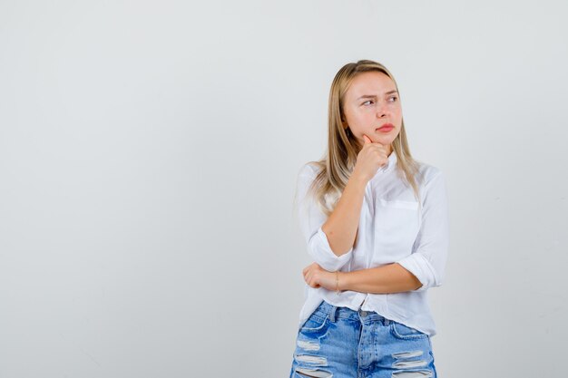 Joven mujer rubia con una camisa blanca