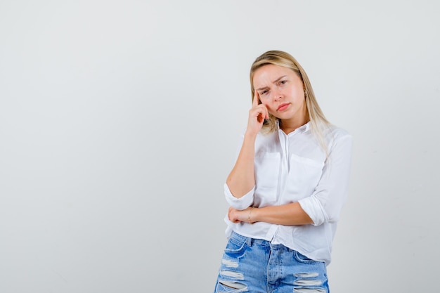 Joven mujer rubia con una camisa blanca