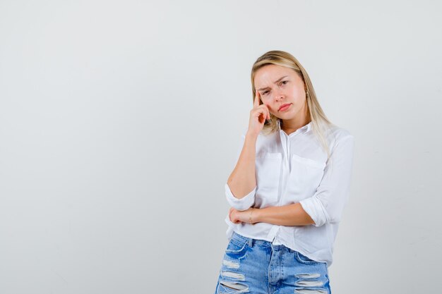 Joven mujer rubia con una camisa blanca