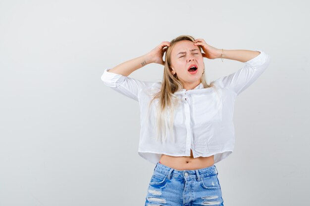 Joven mujer rubia con una camisa blanca