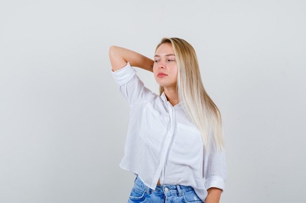 Joven mujer rubia con una camisa blanca