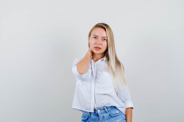 Joven mujer rubia con una camisa blanca