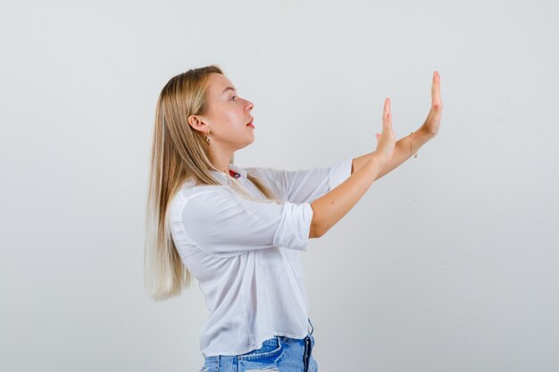 Joven mujer rubia con una camisa blanca