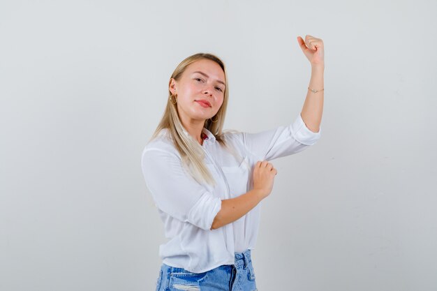 Joven mujer rubia con una camisa blanca