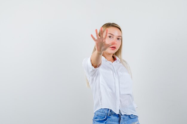 Joven mujer rubia con una camisa blanca