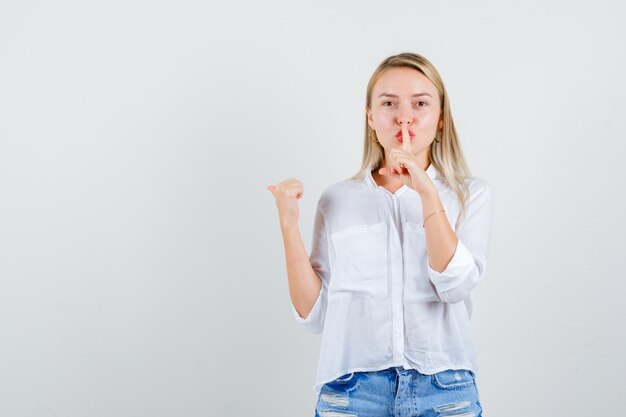 Joven mujer rubia con una camisa blanca