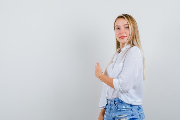 Joven mujer rubia con una camisa blanca