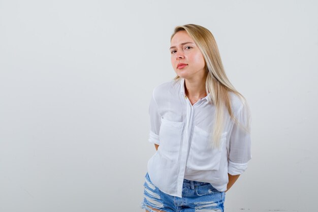 Joven mujer rubia con una camisa blanca