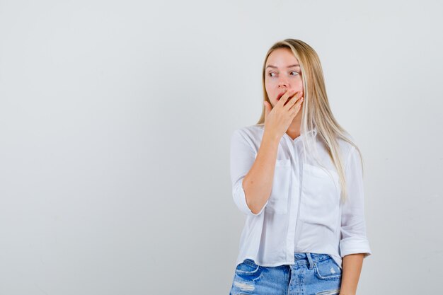 Joven mujer rubia con una camisa blanca