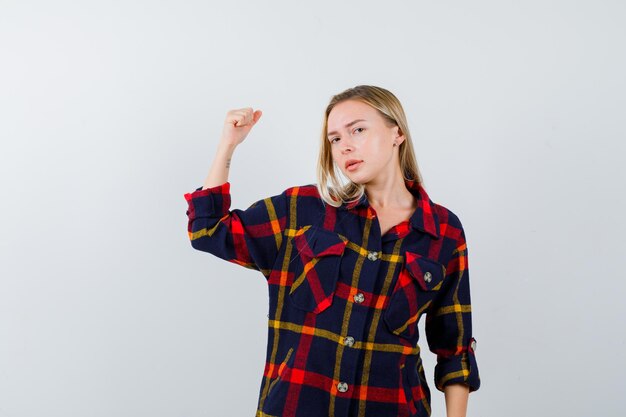 Joven mujer rubia con una camisa a cuadros