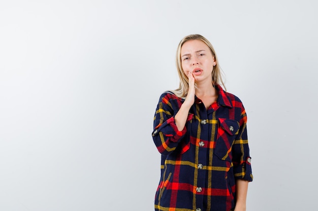 Joven mujer rubia con una camisa a cuadros