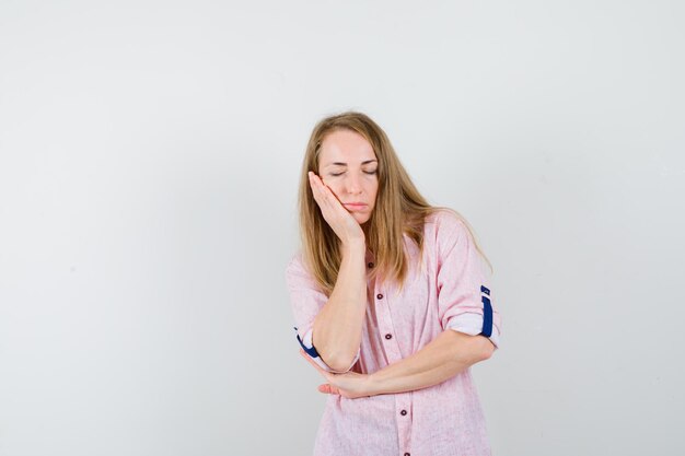 Joven mujer rubia con una camisa rosa casual