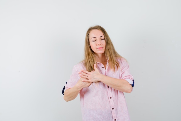 Foto gratuita joven mujer rubia con una camisa rosa casual