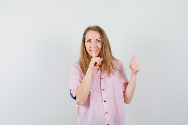 Joven mujer rubia con una camisa rosa casual